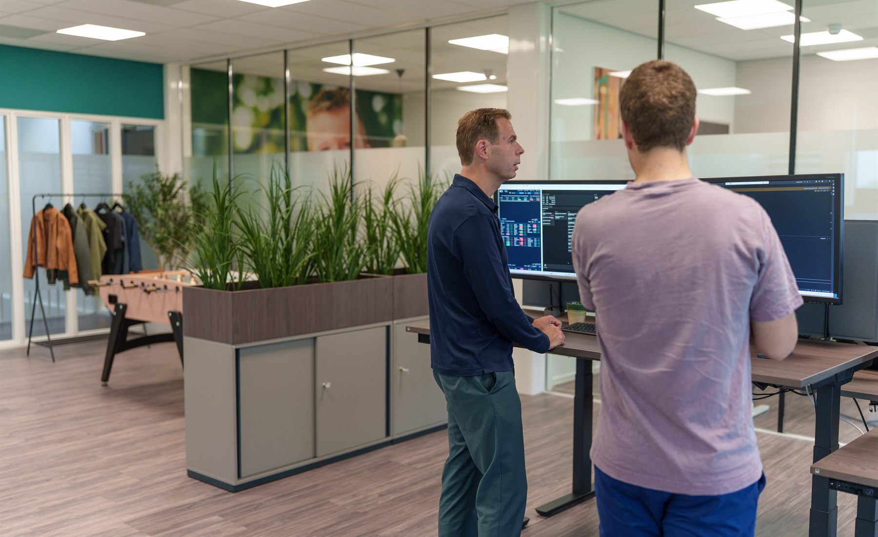 Twee collega’s overleggen aan een bureau in het kantoor van Quant Atelier